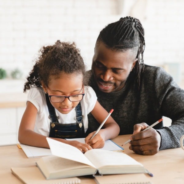 A dad and daughter are working on her homework together