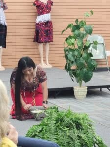 A woman grinding corn on stone and making tortillas.
