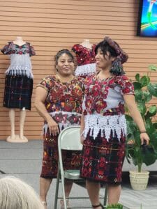 A mother demonstrating how to style her daughter’s hair with a traditional woven hair band.